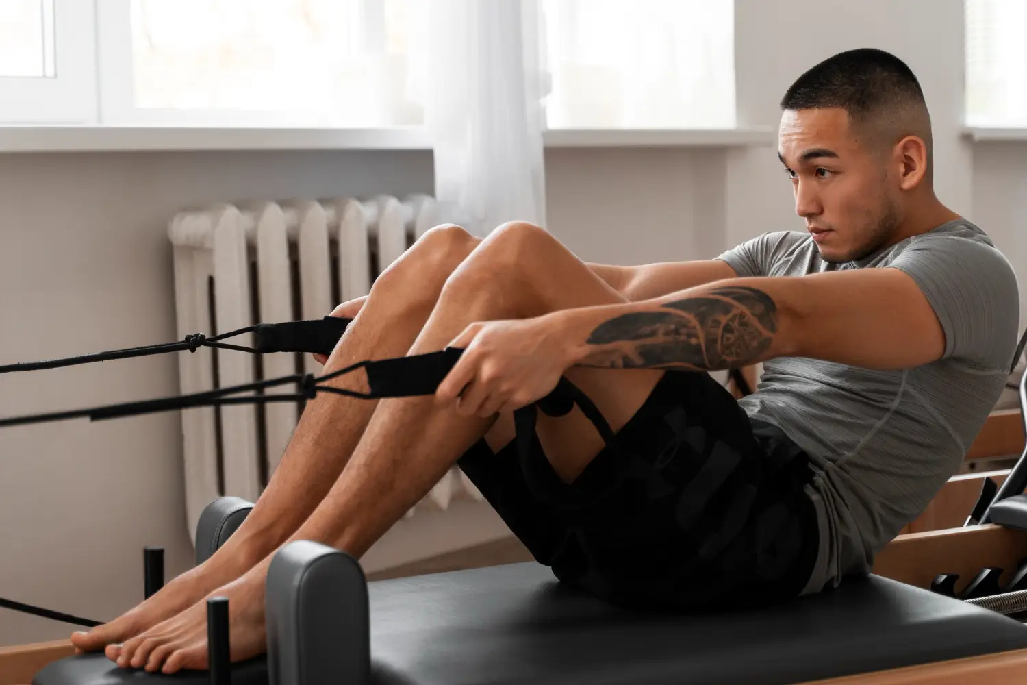 Full shot man taking pilates reformer class